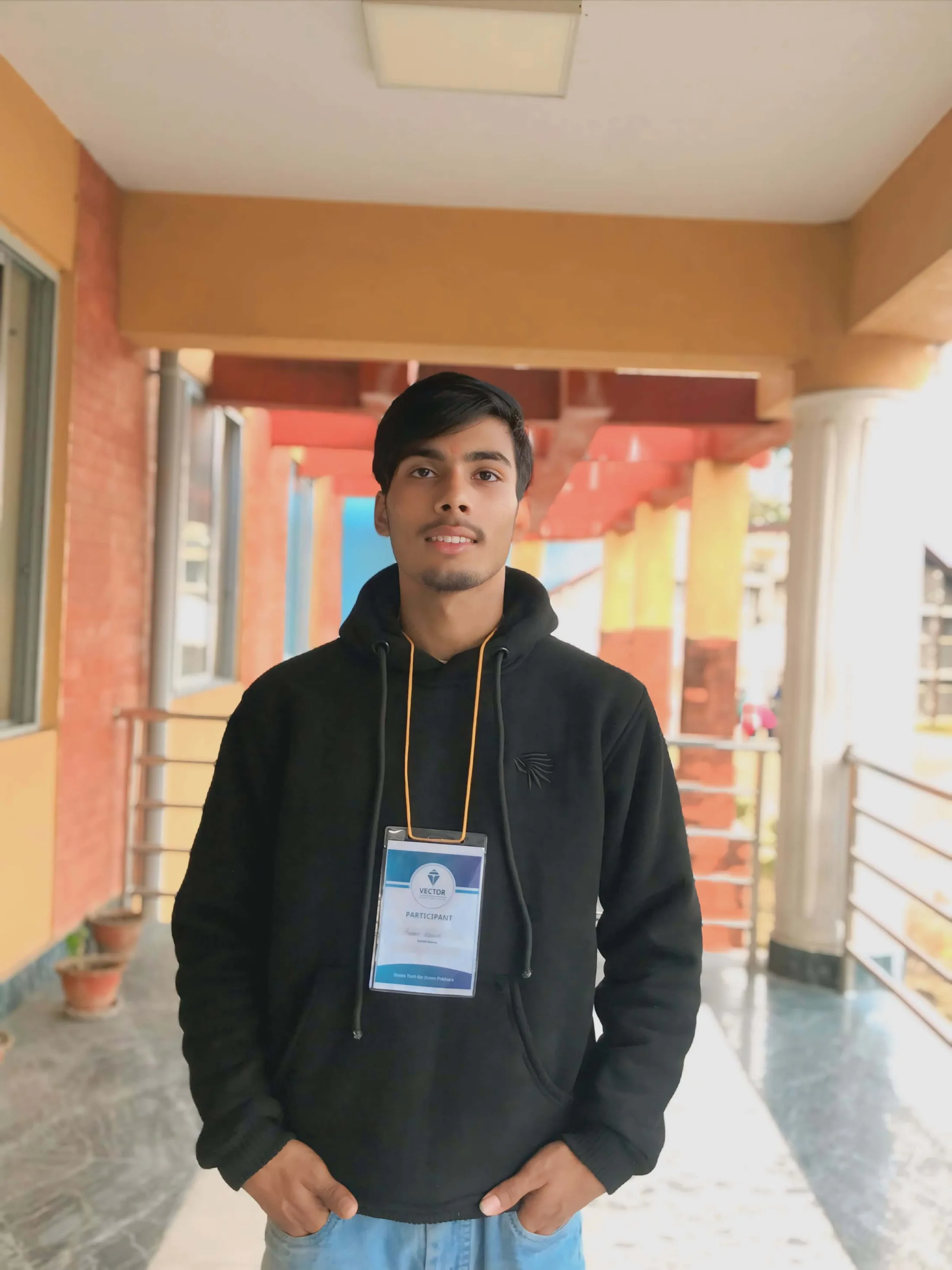 Prabin Kandel standing in front of a painted mural